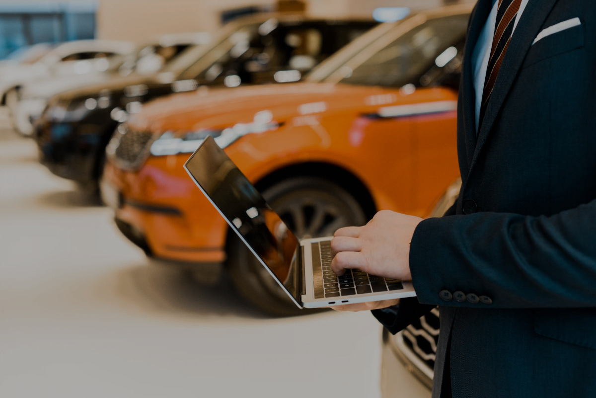 Google Ads for dealerships showing a dealer using a laptop in a car showroom